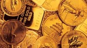Monton de distintas monedas y lingotes de oro